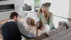 Happy family with two kids enjoy time together on couch in living room