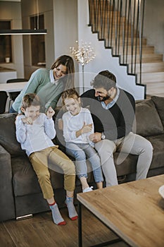 Happy family with two kids enjoy time together on couch in living room