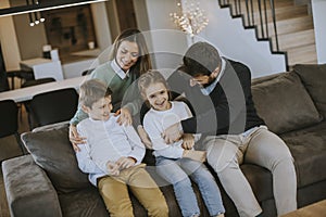 Happy family with two kids enjoy time together on couch in living room