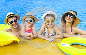 Happy family with two kids having fun in the swimming pool