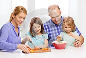 Happy family with two kids making dinner at home