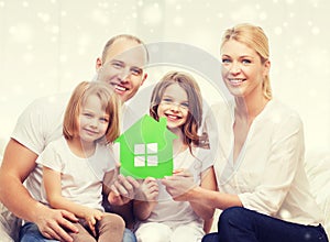 Happy family with two kids and paper house at home