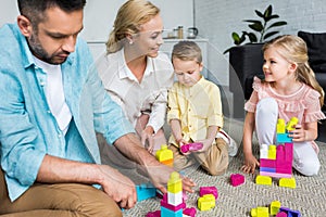 happy family with two kids playing with colorful blocks