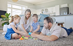 Happy family with two kids playing with colourful building blocks at home. Parents bonding with their two kids at home