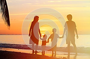 Happy family with two kids on sunset beach