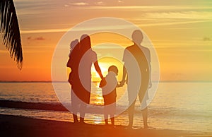 Happy family with two kids on sunset beach