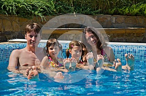 Happy family with two kids in swimming pool