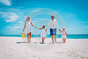 Happy family with two kids walk on tropical beach
