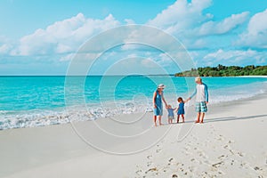 Happy family with two kids walk on tropical beach
