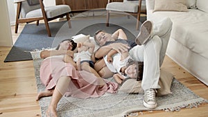 Happy family with two little children relaxing at home