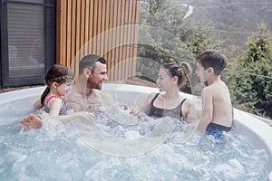 Happy family with two small children have fun in the jacuzzi