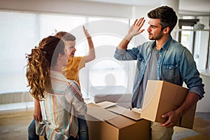 Happy family unpacking boxes in new home on moving day