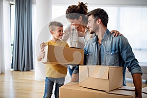 Happy family unpacking boxes in new home on moving day