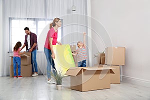 Happy family unpacking boxes in their new house