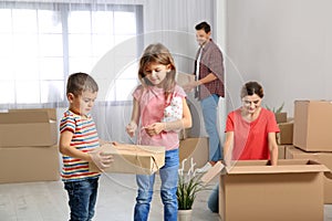 Happy family unpacking boxes in their new house
