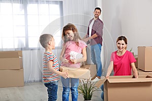 Happy family unpacking boxes in their new house