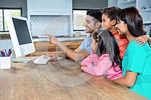 Happy family using computer in the kitchen