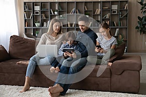Happy family using different gadgets at home.