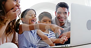 Happy family using laptop in living room