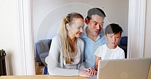 Happy family using laptop in living room