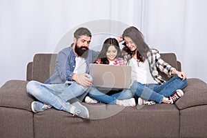 Happy family using laptop. Stay online. little girl with parents. mother and bearded father with daughter looking at