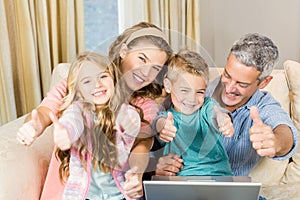 Happy family using laptop with thumbs up