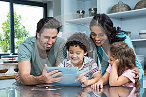 Happy family using tablet in kitchen