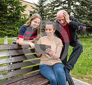 Happy family using tablet PC outdoors