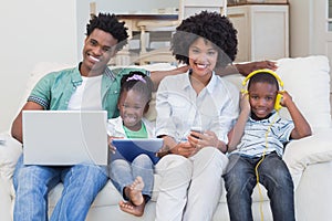 Happy family using technologies on the couch