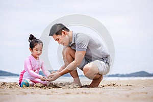 Happy family. Happy vacation holiday. Happy father and daughter are building a sandcastle on the tropical beach and have fun
