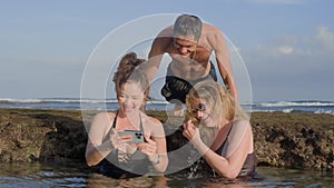 Happy family on vacation looking through pictures of their holiday moments together as they are chilling inside reef