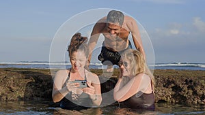 Happy family on vacation looking through pictures of their holiday moments together as they are chilling inside reef