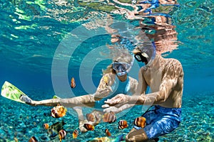 Young couple in snorkeling mask dive underwater in tropical sea