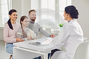 Happy family on a visit to the doctor in the office of a doctor.