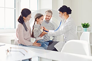 Happy family on a visit to the doctor in the office of a doctor.