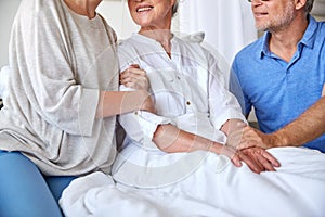 Happy family visiting senior woman at hospital