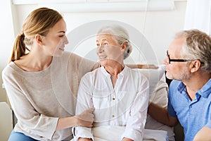 Happy family visiting senior woman at hospital