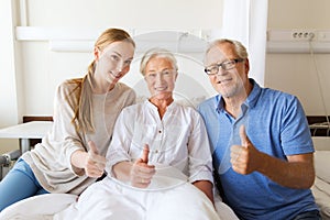 Happy family visiting senior woman at hospital