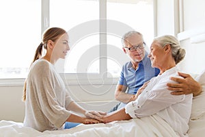 Happy family visiting senior woman at hospital