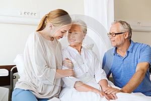 Happy family visiting senior woman at hospital