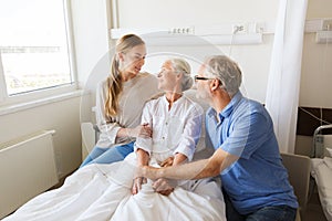 Happy family visiting senior woman at hospital