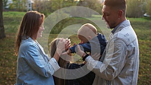 Happy family for a walk in the autumn park. Mother, father and children bvo. The eldest daughter and youngest son