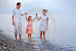 Happy family walk on beach, having joined hands