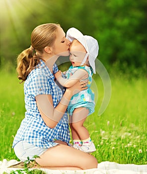 Happy family on a walk. mother kissing baby