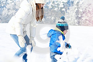 Happy family on the walk in sunny, snowy day - winter holidays