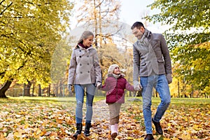 Happy family walking at autumn park