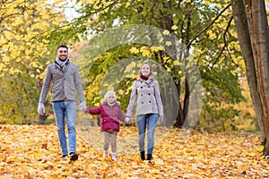 Happy family walking at autumn park