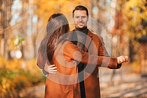 Happy family walking in autumn park on sunny fall day