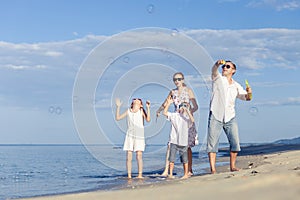 Happy family walking on the beach at the day time.