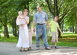 Happy family walking in city park, group of five people, summer season, child and parent